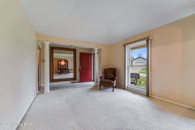 unfurnished room with ornate columns, light carpet, and vaulted ceiling