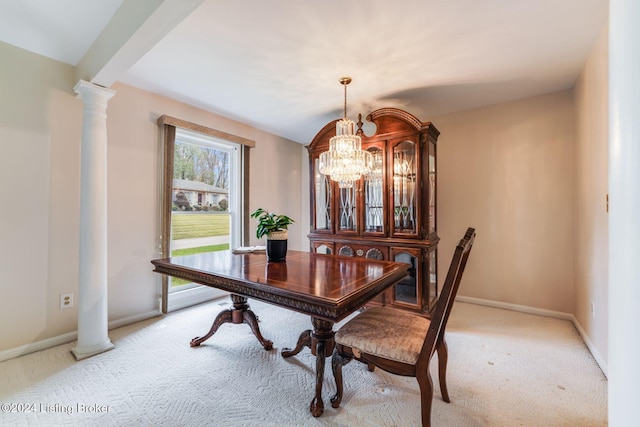 dining area featuring an inviting chandelier, light colored carpet, and decorative columns