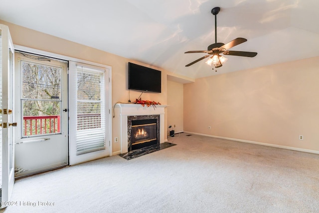 unfurnished living room with ceiling fan, a premium fireplace, light carpet, and lofted ceiling