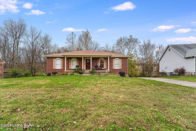 ranch-style home featuring covered porch and a front yard