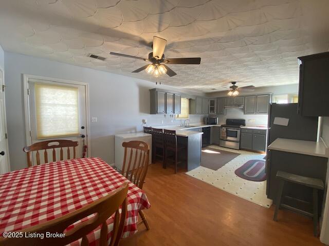 dining space with hardwood / wood-style flooring and ceiling fan