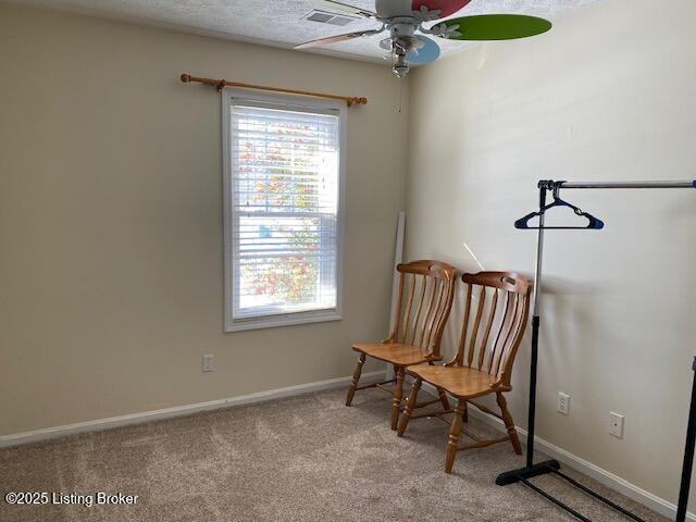 living area featuring light carpet and ceiling fan