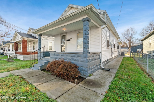 bungalow-style home featuring a porch and a front yard