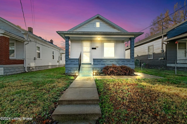 bungalow-style house with a lawn and covered porch