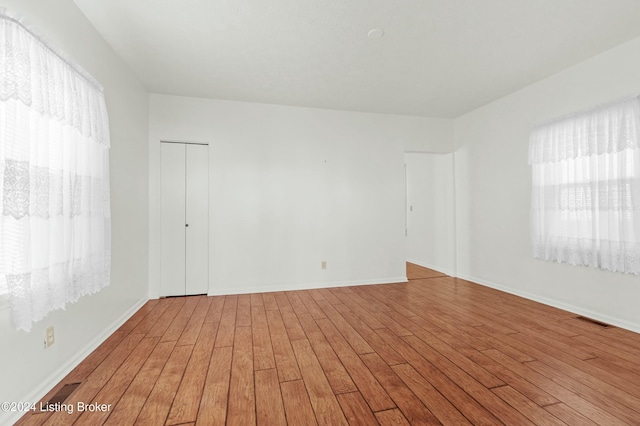 unfurnished room with hardwood / wood-style flooring and plenty of natural light