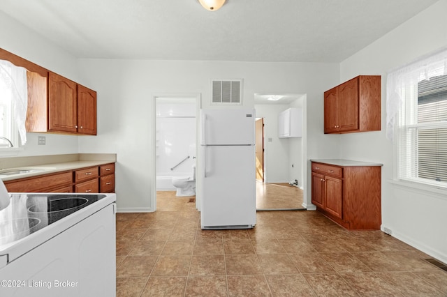 kitchen featuring white appliances, sink, and light tile patterned floors