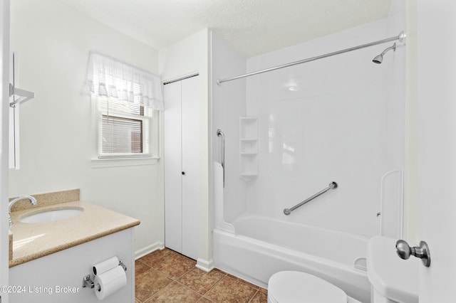 full bathroom with tile patterned floors, vanity, a textured ceiling, washtub / shower combination, and toilet