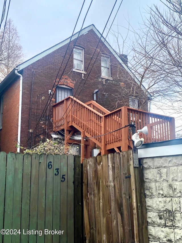 rear view of property featuring a wooden deck