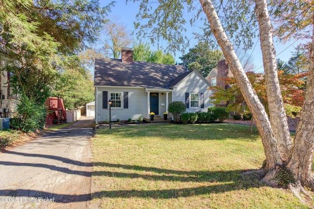 view of front of house with a garage, a front lawn, and an outdoor structure