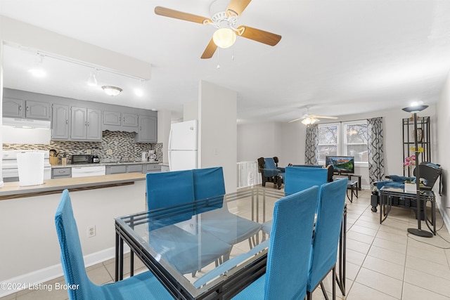 dining area with light tile patterned floors, rail lighting, and ceiling fan