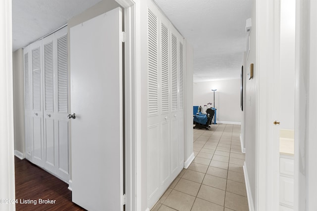 hallway with light tile patterned floors and a textured ceiling