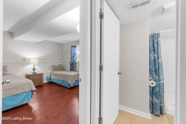 bedroom featuring hardwood / wood-style floors and a textured ceiling