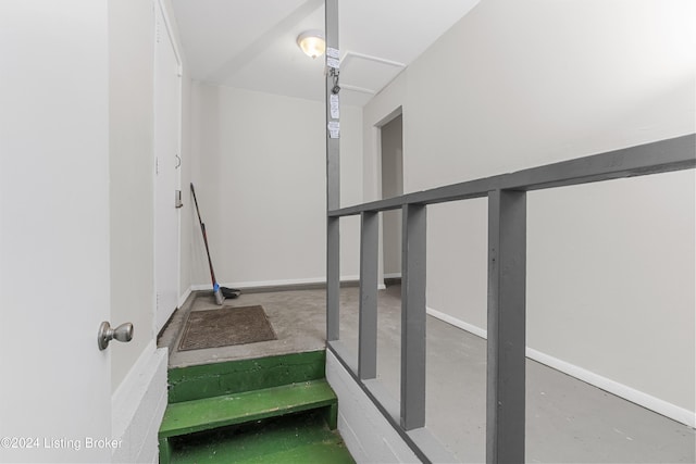 stairs featuring concrete flooring