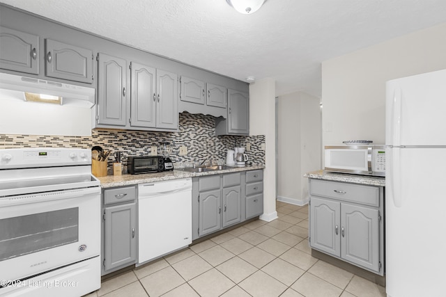 kitchen featuring gray cabinets, decorative backsplash, sink, and white appliances