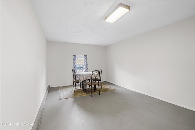 dining room featuring concrete floors and a textured ceiling