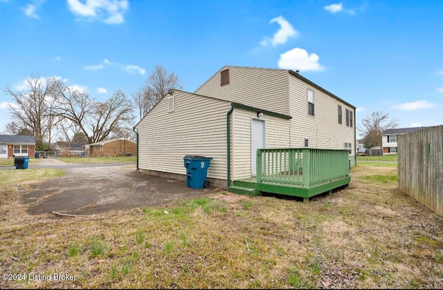 view of side of property featuring a yard and a deck