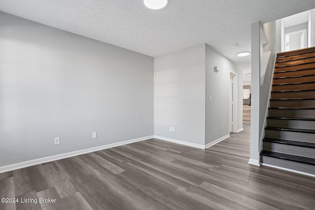 unfurnished room featuring a textured ceiling and dark hardwood / wood-style floors