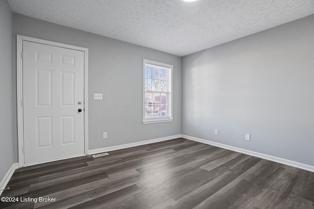 unfurnished room featuring a textured ceiling and dark wood-type flooring