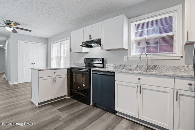 kitchen featuring light stone counters, a textured ceiling, sink, black appliances, and white cabinetry