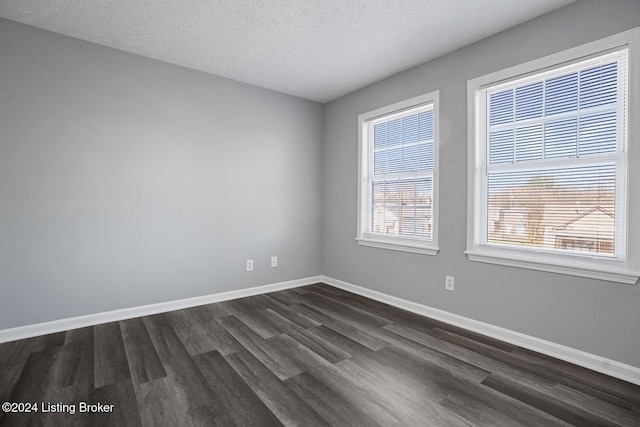 unfurnished room featuring dark wood-type flooring and a textured ceiling