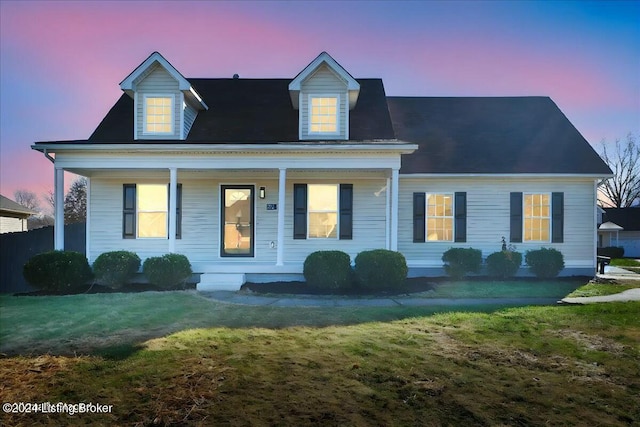 new england style home with a porch and a lawn