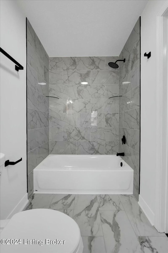 bathroom featuring toilet and tiled shower / bath