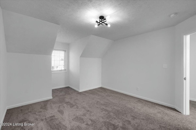 bonus room with a textured ceiling, carpet floors, and lofted ceiling