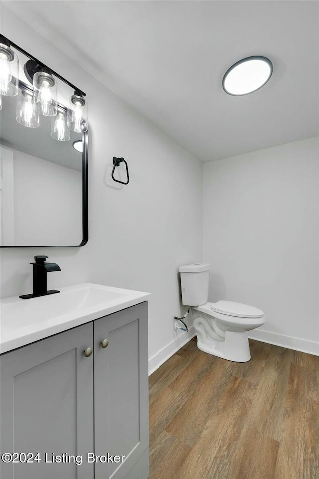 bathroom featuring toilet, vanity, and hardwood / wood-style flooring