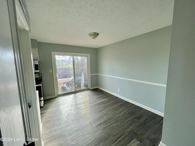 empty room featuring dark hardwood / wood-style flooring and a textured ceiling