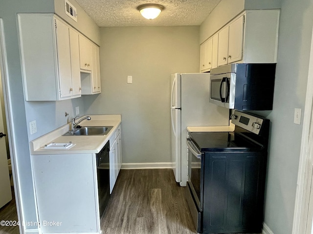 kitchen featuring sink, dark hardwood / wood-style floors, a textured ceiling, white cabinetry, and stainless steel appliances