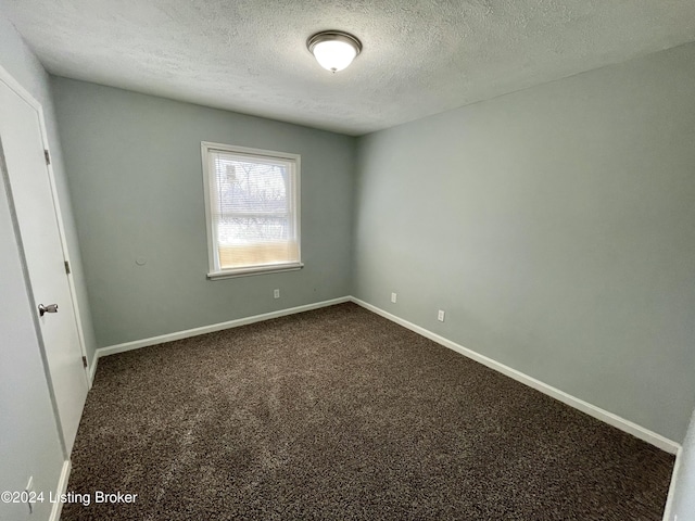 spare room featuring carpet floors and a textured ceiling