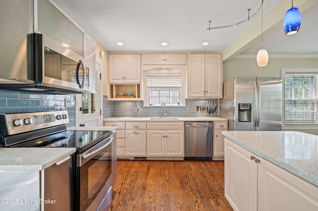 kitchen with sink, light stone countertops, hanging light fixtures, and appliances with stainless steel finishes