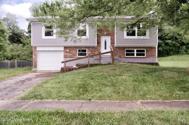 split foyer home featuring a garage and a front lawn