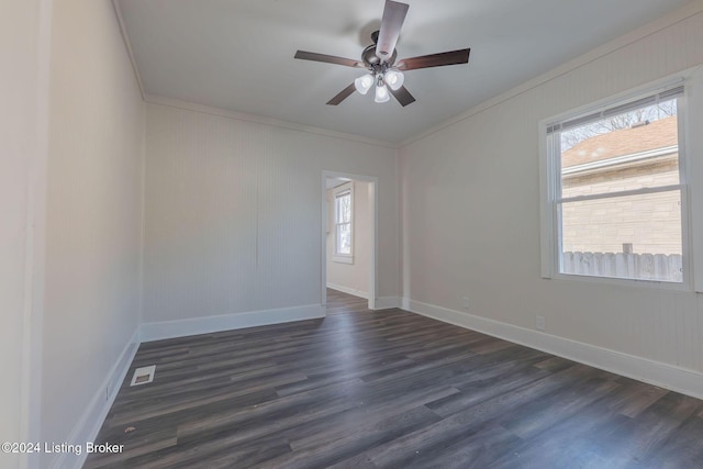 empty room with ceiling fan, crown molding, and dark wood-type flooring