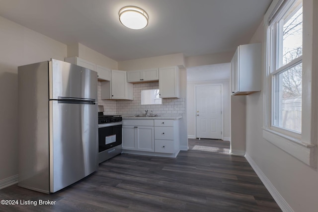 kitchen featuring sink, dark hardwood / wood-style floors, decorative backsplash, white cabinetry, and stainless steel appliances