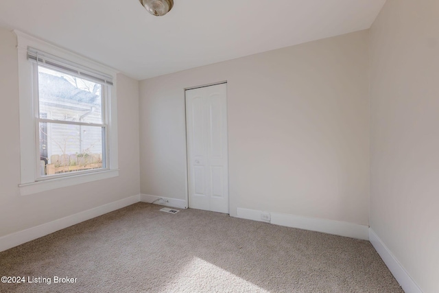 unfurnished bedroom featuring a closet and carpet floors