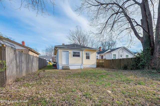 back of house with a lawn