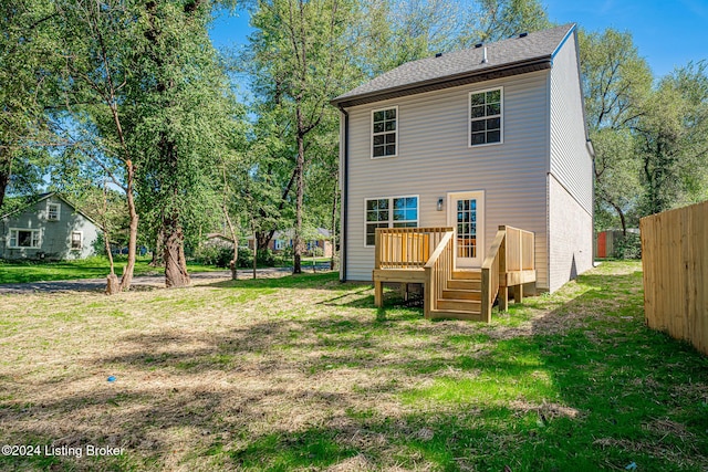 rear view of house with a deck and a lawn