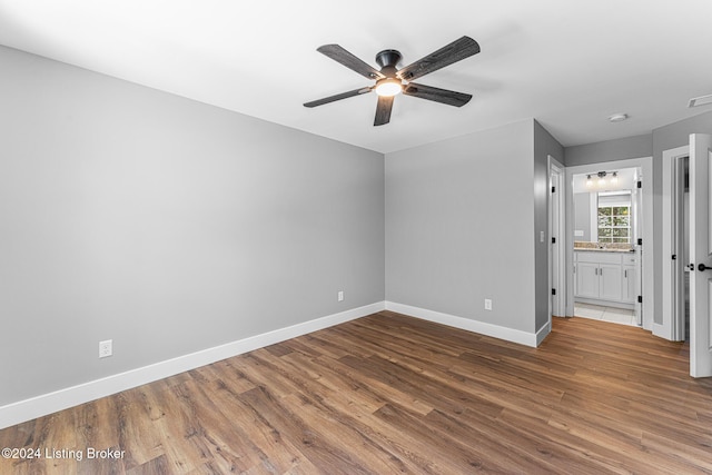 interior space with hardwood / wood-style flooring, ensuite bath, and ceiling fan