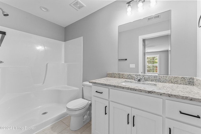 bathroom featuring tile patterned flooring, toilet, a shower, and vanity