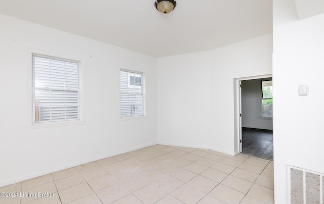 spare room with light tile patterned floors and a healthy amount of sunlight