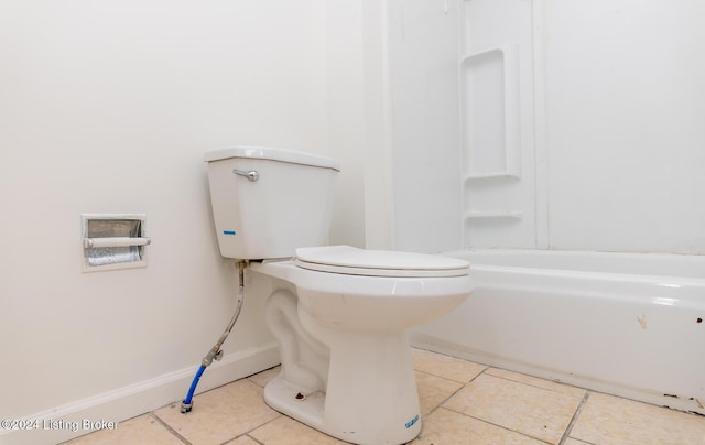 bathroom featuring tile patterned floors, a washtub, and toilet