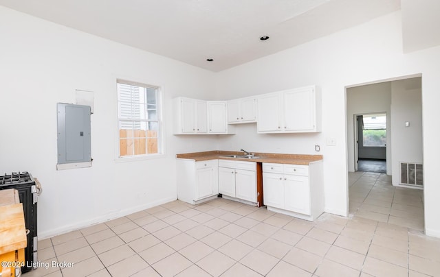 kitchen with electric panel, white cabinetry, sink, and light tile patterned floors