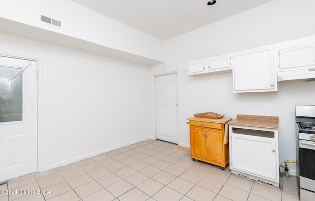 kitchen with white cabinetry, light tile patterned flooring, white range, and ventilation hood