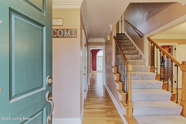 staircase featuring hardwood / wood-style floors and ornamental molding