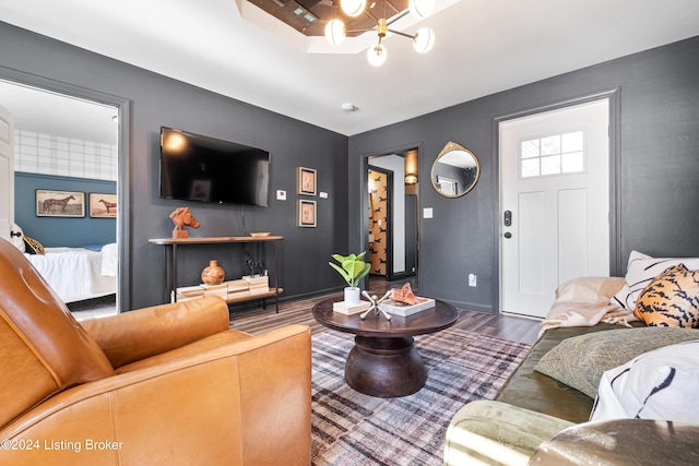 living room with hardwood / wood-style flooring and a notable chandelier