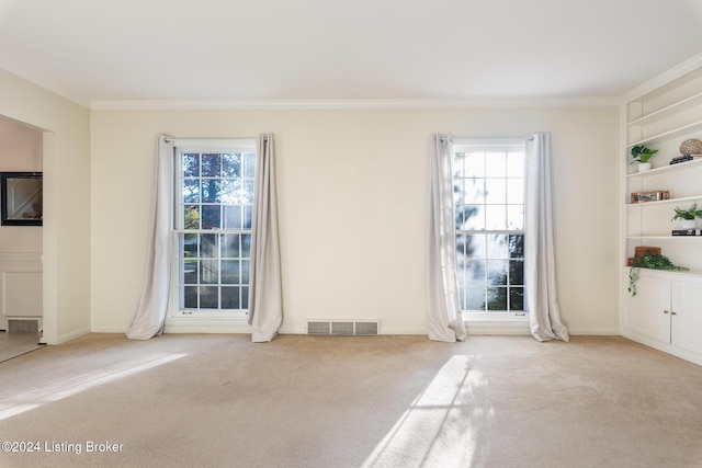 unfurnished living room with light colored carpet, a wealth of natural light, and ornamental molding