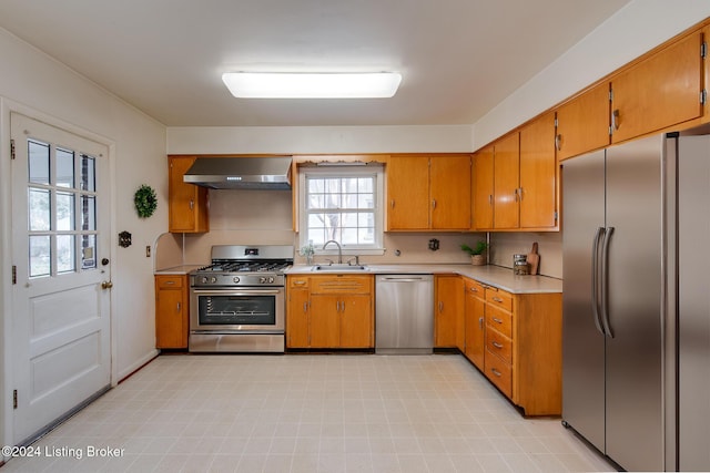 kitchen featuring sink, wall chimney range hood, and stainless steel appliances