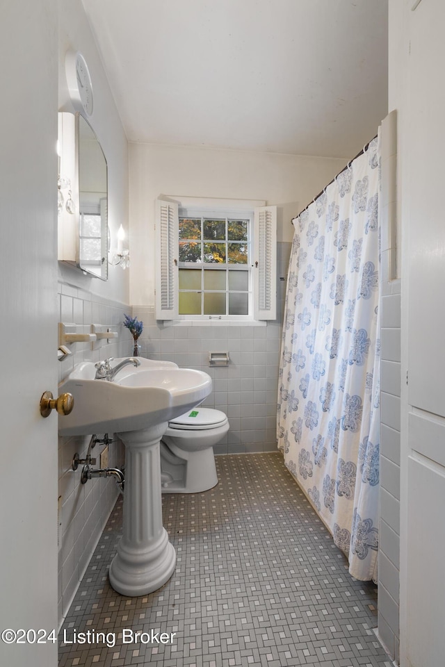 bathroom with walk in shower, tile walls, and toilet