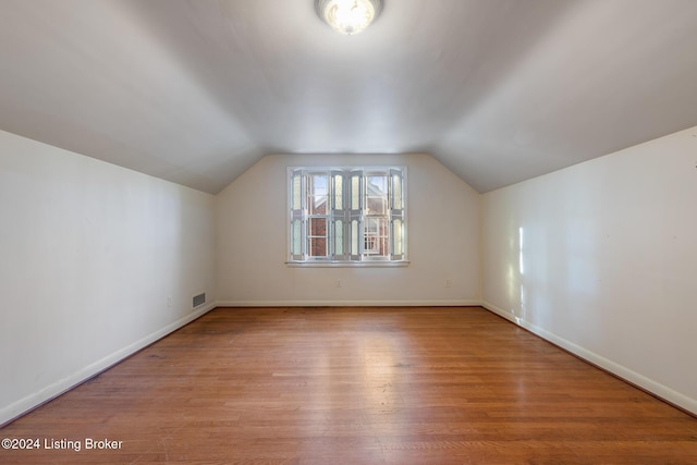 bonus room with vaulted ceiling and light hardwood / wood-style flooring